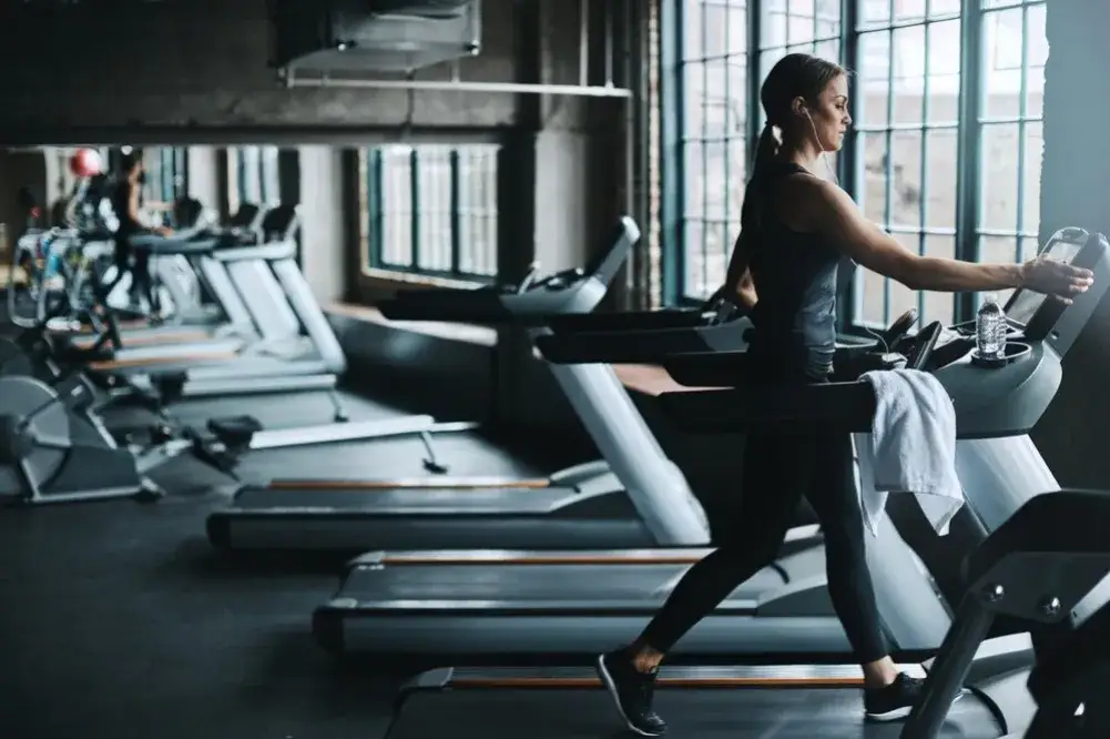 Kobieta wykonująca cardio przed treningiem siłowym na siłowni